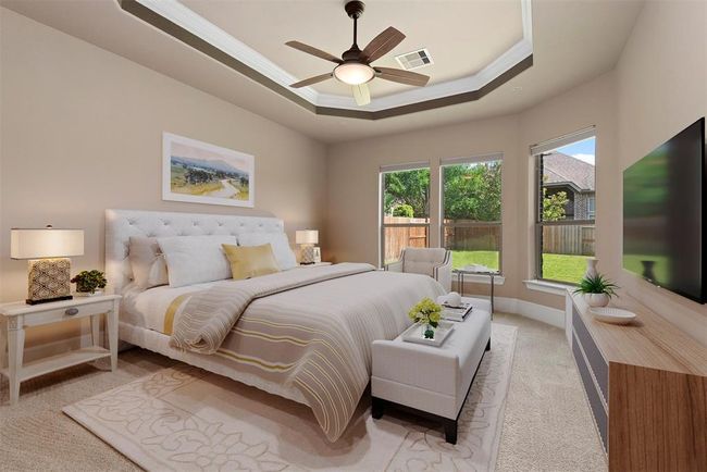 Virtually staged primary bedroom with tray ceiling and wall of windows. | Image 21