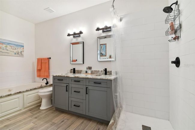 En suite bathroom trimmed with beautiful granite, garden tub, separate shower & dual sink vanity! | Image 15