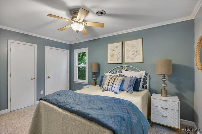 Bedroom with carpet, crown molding, and ceiling fan with light, closets, window | Image 22