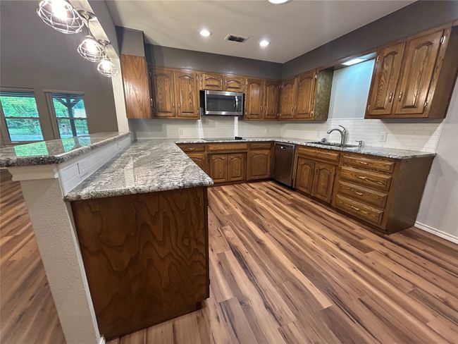 Kitchen featuring appliances with stainless steel finishes, wood finished floors, and recessed lighting | Image 15