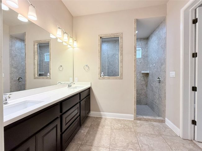 Full bathroom with double vanity, a walk in shower, and tile patterned flooring | Image 31