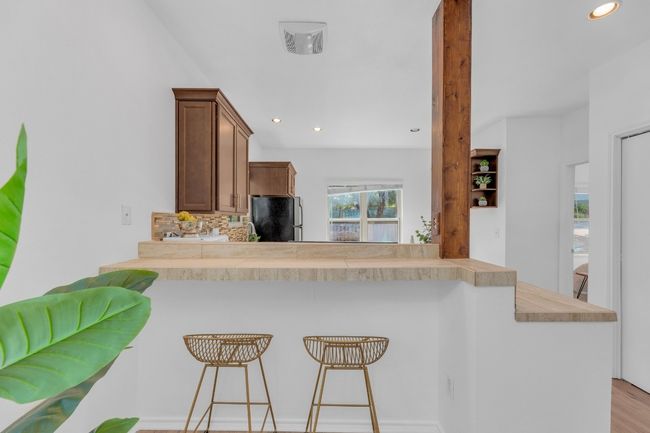 Kitchen with freestanding refrigerator, backsplash, a breakfast bar, recessed lighting, and a peninsula | Image 9