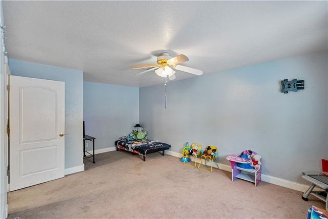 Playroom featuring a textured ceiling, ceiling fan, and carpet | Image 43