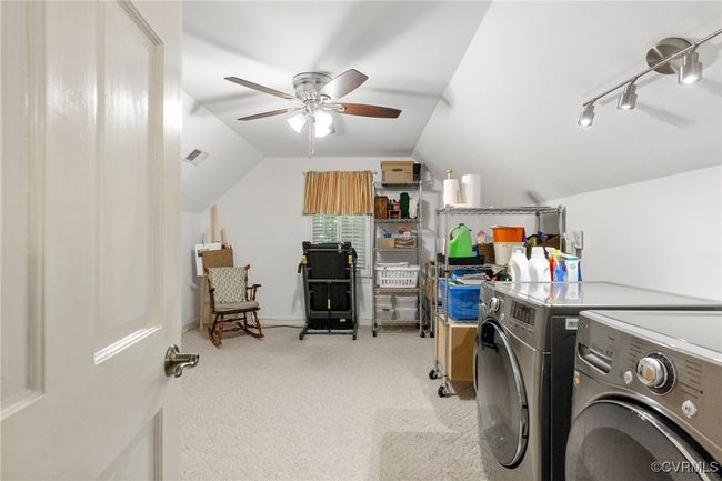 Laundry room featuring washing machine and dryer, a ceiling fan, and carpet | Image 29