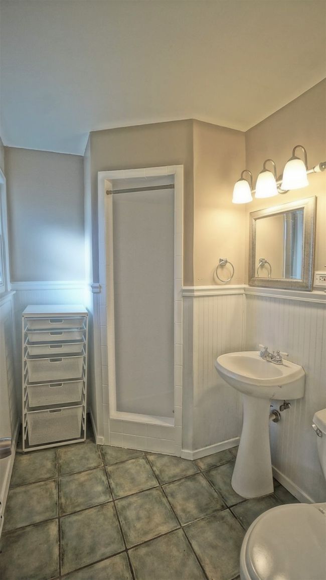 Bathroom featuring a wainscoted wall, tile patterned flooring, and a shower stall | Image 11