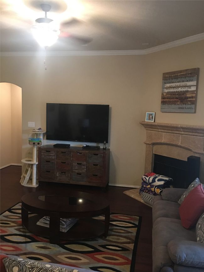 Living area featuring crown molding, arched walkways, wood finished floors, baseboards, and a premium fireplace | Image 6