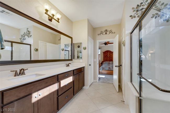 Full bath with visible vents, double vanity, connected bathroom, a sink, and tile patterned flooring | Image 28