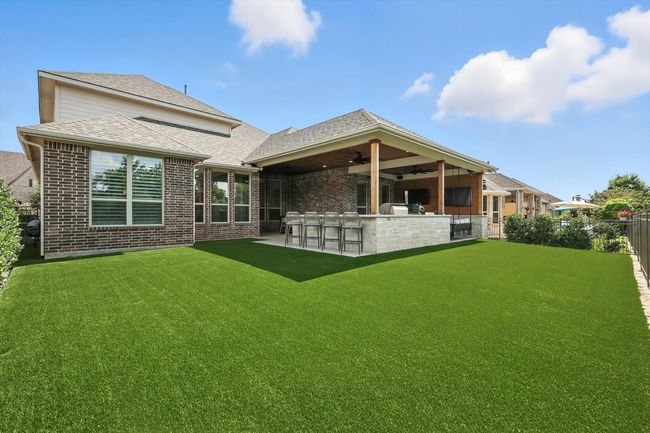 Back of house featuring a ceiling fan, brick siding, a shingled roof, and a patio | Image 34