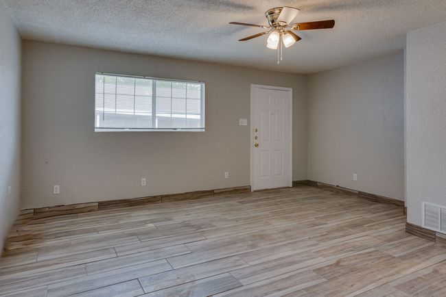 Unfurnished room featuring light wood-style floors, visible vents, ceiling fan, and a textured ceiling | Image 19