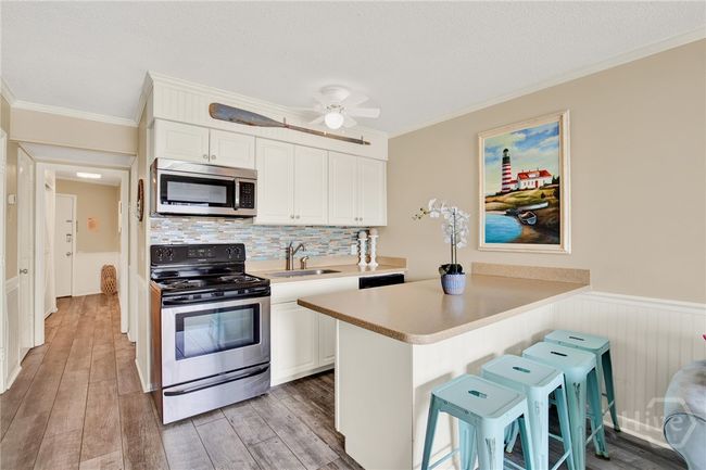 Full Sized Kitchen with Stainless Steel Appliances, Ceiling Height Cabinets, Island with Barstool Seating & Pantry. | Image 9