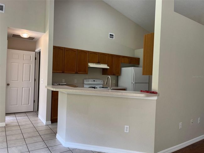 KITCHEN LOOKING INTO HALL TO PRIMARY BEDROOM AND LAUNDRY ROOM TO GARAGE | Image 6