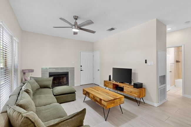 Living room featuring a ceiling fan and a tile fireplace | Image 17