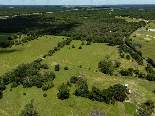 Aerial overview of property's location featuring a heavily wooded area and rural landscape | Image 11