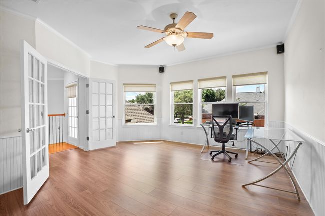 Office featuring french doors, healthy amount of natural light, ceiling fan, a wainscoted wall, and ornamental molding | Image 24