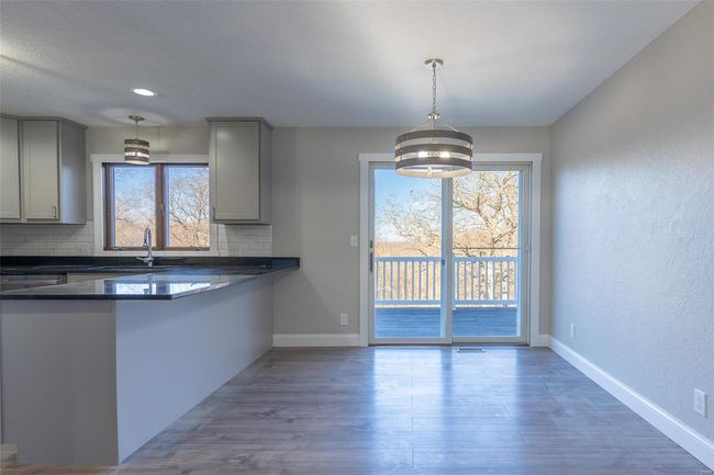 Kitchen with backsplash, gray cabinets, a chandelier, and decorative light fixtures | Image 34