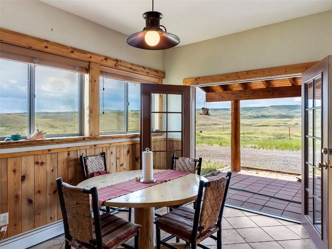 Tiled dining room featuring baseboard heating, a wealth of natural light, ceiling fan, and a rural view | Image 23