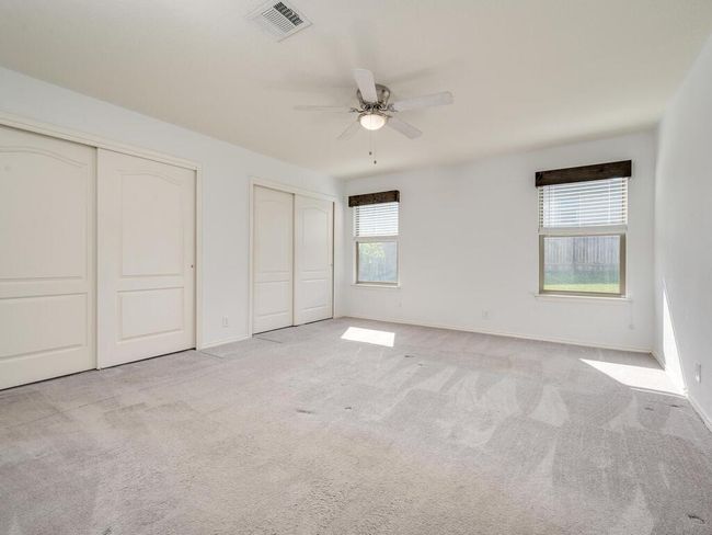 Primary bedroom featuring two closets, carpet floors, and a ceiling fan. | Image 15