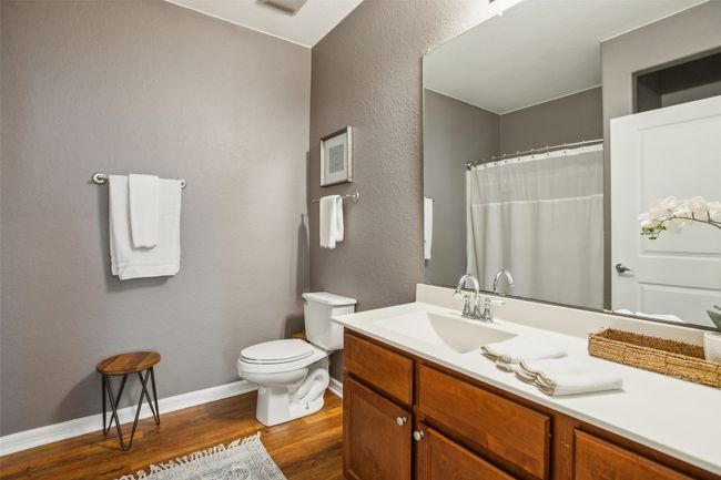 Bathroom 2 with a textured wall, baseboards, toilet, wood plank laminate flooring, and vanity | Image 20