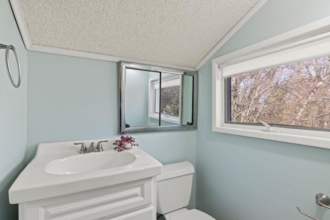 Bathroom featuring toilet, vanity, lofted ceiling | Image 14