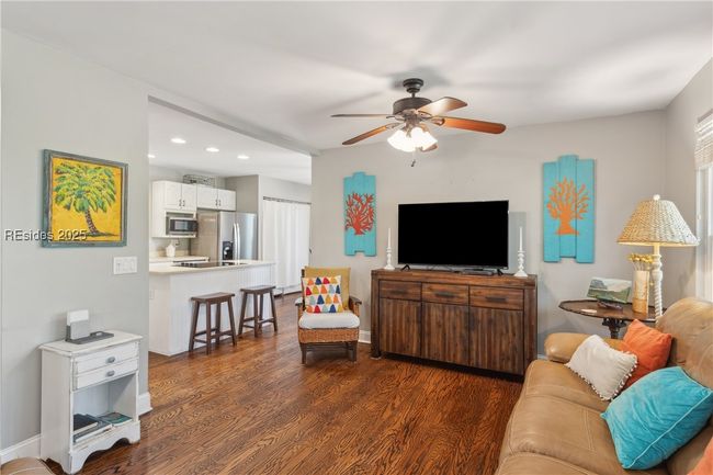 Primary living room with hardwood floors, ample seating, bright natural lighting, smooth ceilings. | Image 34