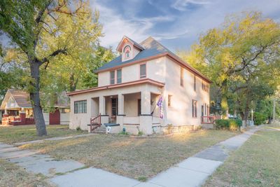 View of front of home with covered porch and a front yard | Image 1