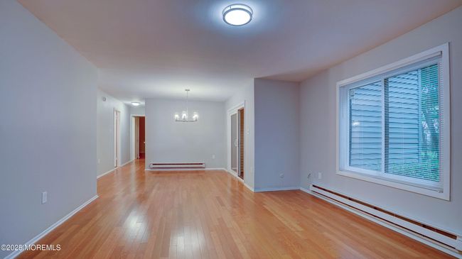 Large living room/dining room freshly painted with hardwood floors. | Image 6