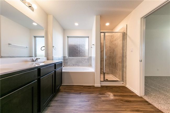 Bathroom featuring vanity, a garden tub, a shower stall, and wood finished floors | Image 9