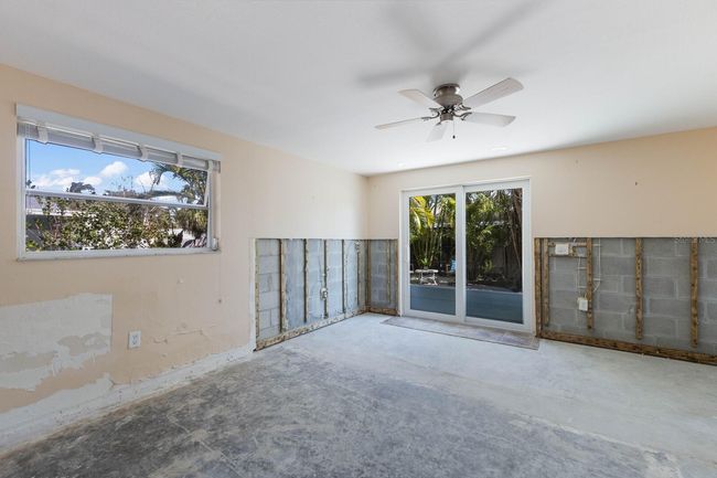 The enlarged guest room has plenty of natural light and a storm rated slider leading to a secluded brick paver patio. | Image 13