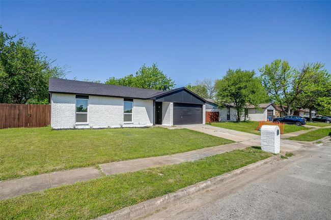 Mid-century home featuring driveway, brick siding, a garage, and a shingled roof | Image 25