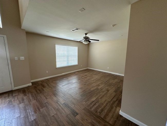Empty room featuring dark wood-type flooring and a ceiling fan | Image 8