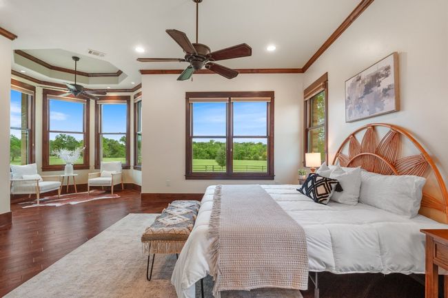 Primary suite with sitting area at bay window and views of pastures. | Image 18