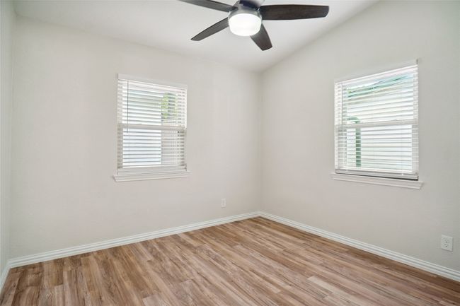 Bedroom with light wood finished floors, healthy amount of natural light and a ceiling fan with remote | Image 14