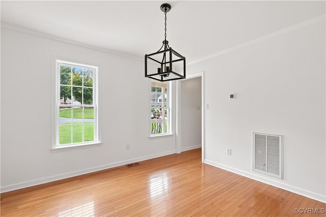 Dining room featuring a chandelier, ornamental molding, light wood-style floors, and healthy amount of natural light | Image 12