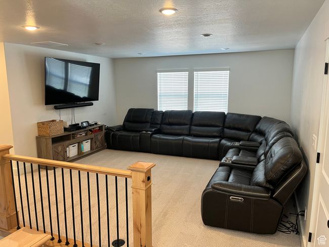Living area with carpet flooring, a textured ceiling, and recessed lighting | Image 13