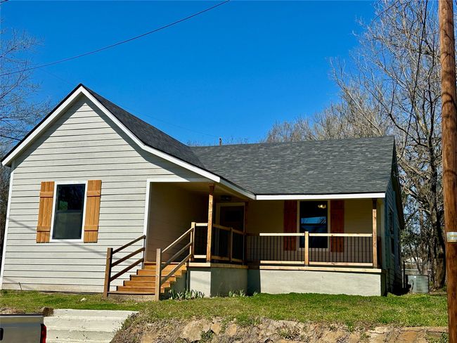 View of front of house featuring covered porch, central AC, and roof with shingles | Image 23