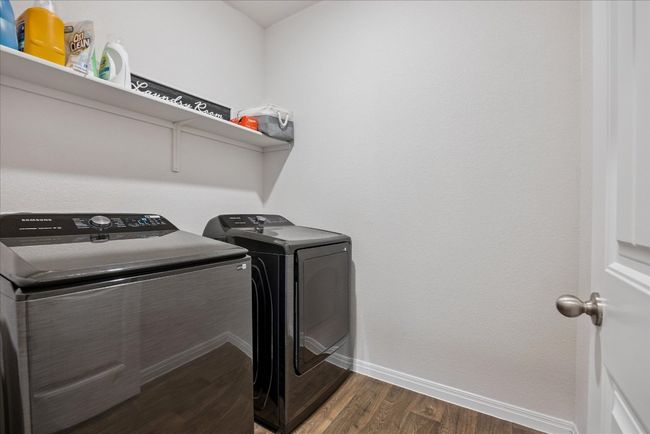 Laundry area featuring wood finished floors and independent washer and dryer | Image 36