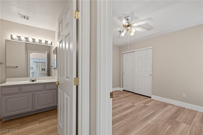 Half bathroom featuring light wood-type flooring, vanity, a textured ceiling, and ceiling fan | Image 15