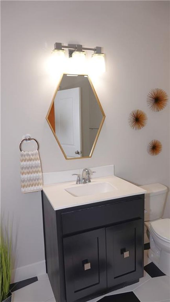 Half bath with toilet, tile patterned flooring, and vanity | Image 42