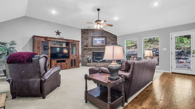 Living room featuring ceiling fan, a brick fireplace, lofted ceiling, and recessed lighting | Image 11