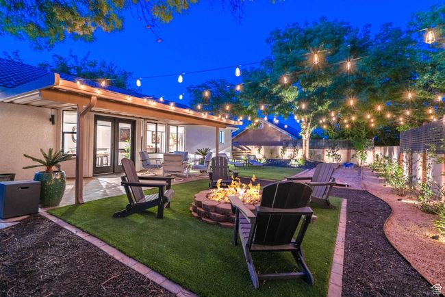 Yard at night with a patio area, an outdoor living space with a fire pit, and french doors | Image 20