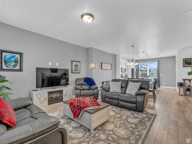 Living room featuring light wood-style flooring and a chandelier | Image 6