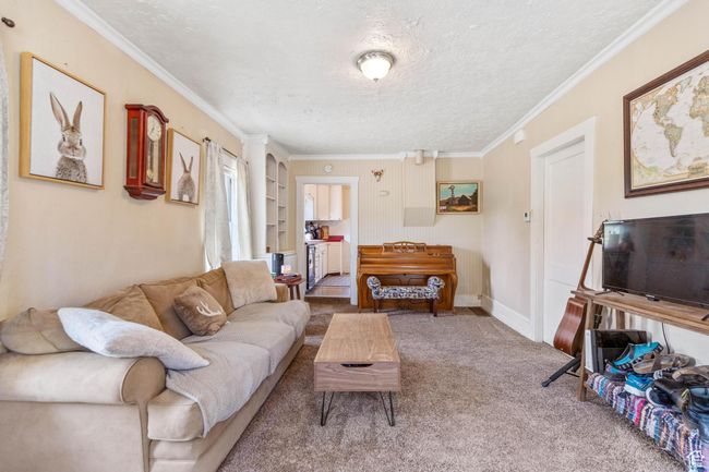 Carpeted living room featuring a textured ceiling and crown molding | Image 6