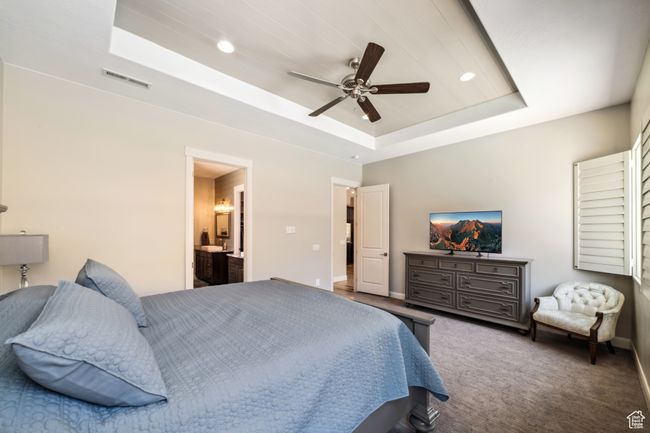 Bedroom with a tray ceiling, baseboards, carpet flooring, visible vents, and recessed lighting | Image 16