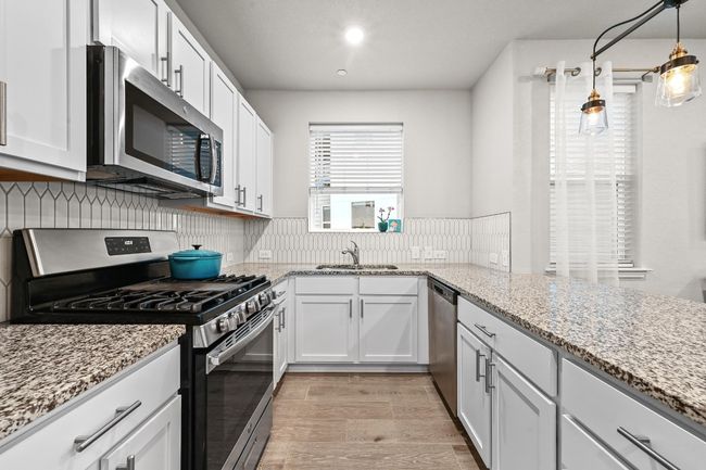 With an expansive breakfast counter and plenty of storage, this kitchen keeps everything you need within reach while maintaining a streamlined, clutter-free look | Image 12