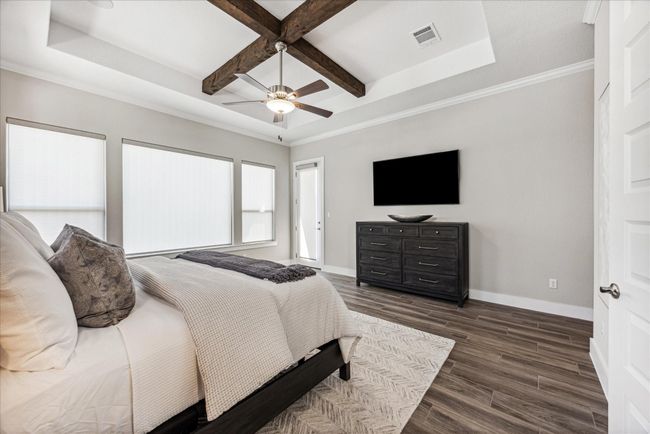 A pop-up ceiling with exposed wood beams adds architectural flair and character to the primary bedroom. Private access the to the covered patio allows you to sneak out and enjoy the early morning sunrise. | Image 20