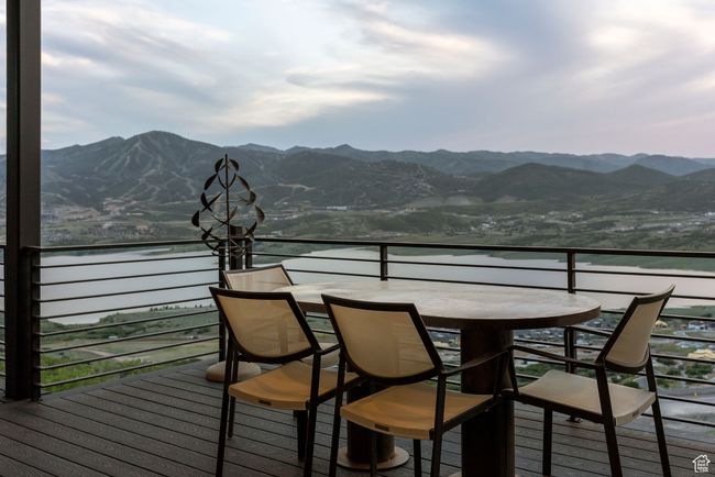 Wooden deck featuring outdoor dining area and a water and mountain view | Image 90