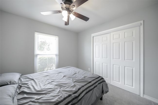 Bedroom with carpet floors, a closet, and a ceiling fan | Image 18