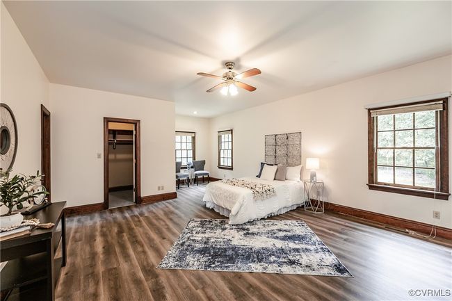 Bedroom with wood finished floors, baseboards, a ceiling fan, and a walk in closet | Image 18