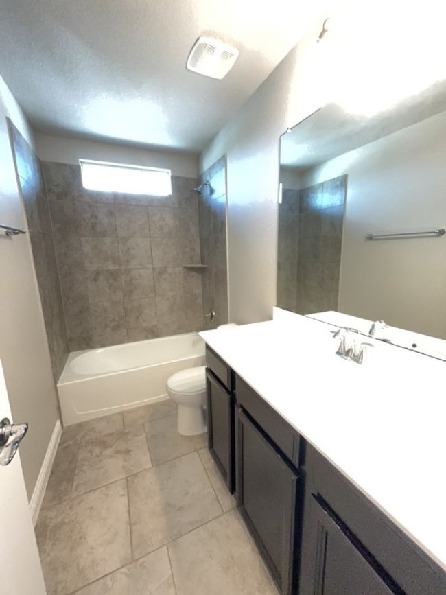 Bathroom featuring vanity, shower / tub combination, and tile patterned floors | Image 20