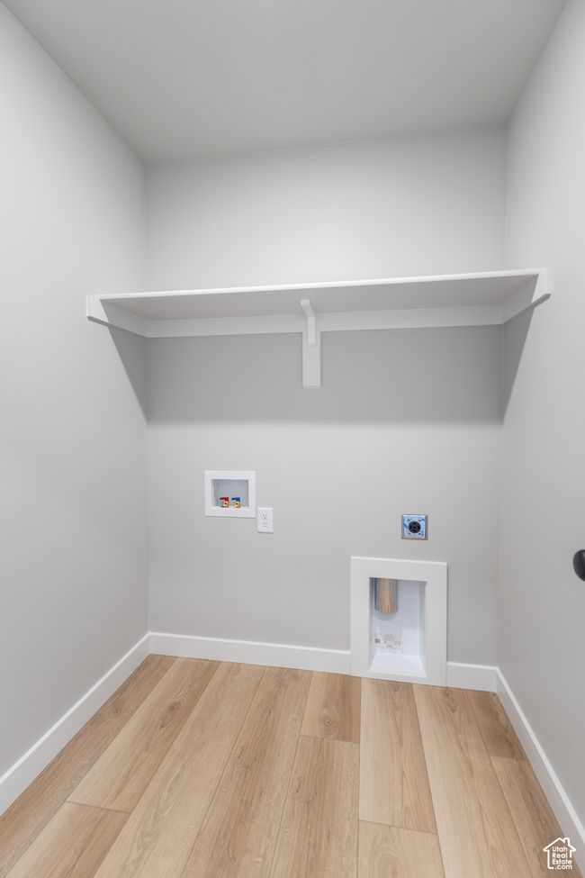 Laundry area with hookup for an electric dryer, wood finished floors, hookup for a washing machine, and baseboards | Image 19